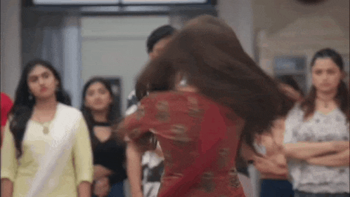 a woman in a red dress is dancing in a crowd of people .