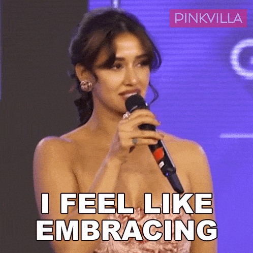 a woman singing into a microphone with the words i feel like embracing above her