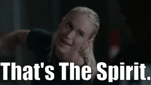 a woman says that 's the spirit in front of a dark background