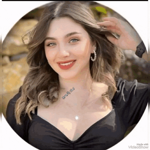 a woman in a black dress with a necklace and earrings is smiling