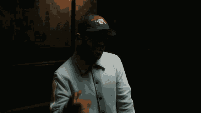 a man wearing a hat that says ' chicago bulls ' on it is giving the middle finger