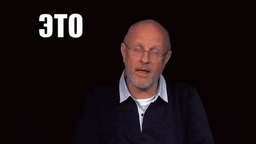 a man with glasses and a beard is speaking in russian .