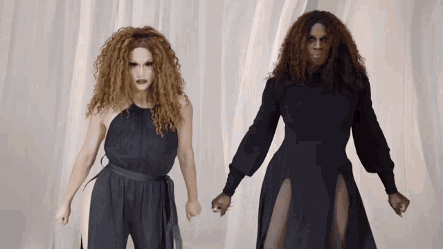 two drag queens are standing next to each other and holding hands