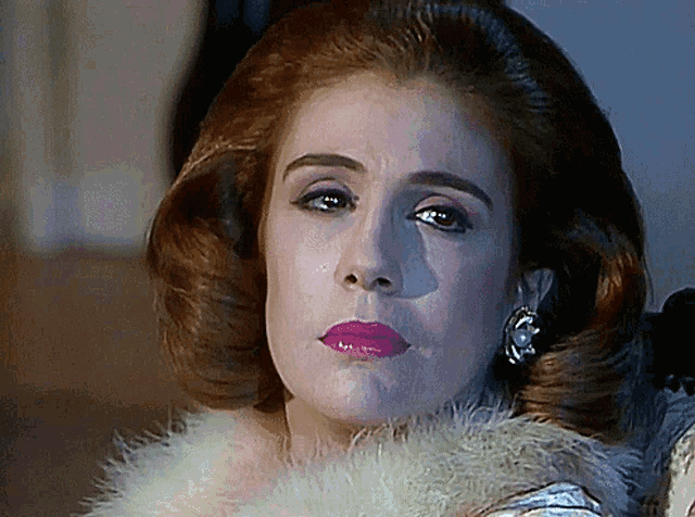 a close up of a woman 's face with a fur collar around her neck
