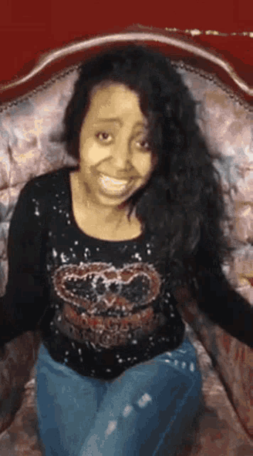 a woman is smiling while sitting on a couch