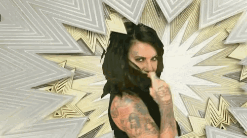 a woman with tattoos on her arms is covering her face with her hand .