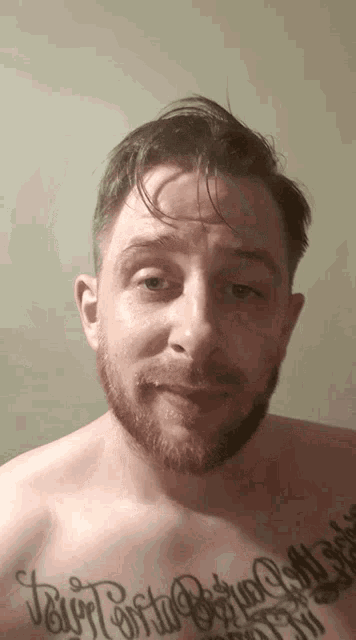 a man with a beard has a tattoo on his chest that says jesus
