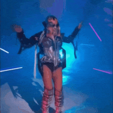 a woman is dancing in a dark room with blue lights