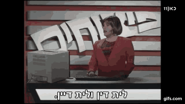 a woman in a red jacket is typing on a computer keyboard in front of a sign that says 111 kc