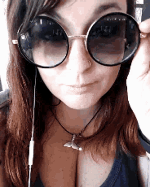 a woman wearing sunglasses and a shark necklace
