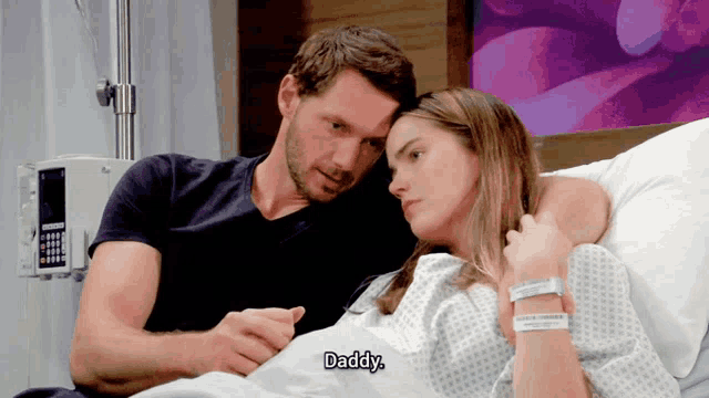 a man and a woman are in a hospital bed and the man says daddy