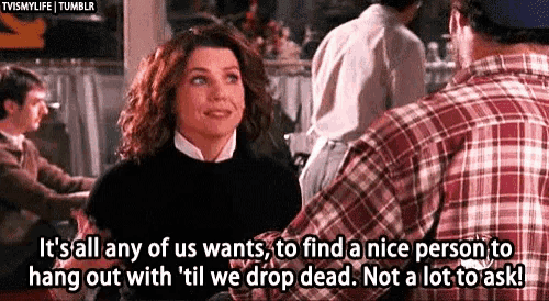 a man in a plaid shirt is talking to a woman in a black sweater