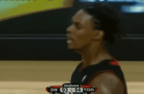 a basketball player stands in front of a scoreboard with the score 93 94 tor on it