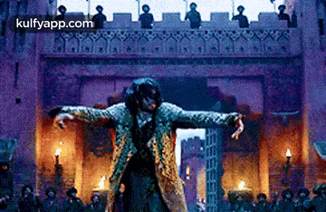 a man is dancing in front of a crowd of people in a castle .