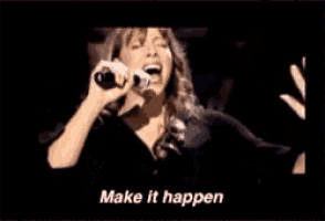 a woman singing into a microphone with the words " make it happen " on the bottom