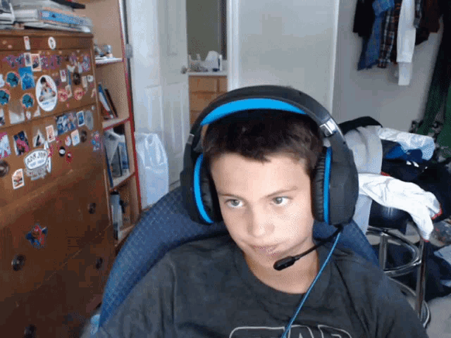 a boy wearing headphones and a shirt that says ' star wars ' on it