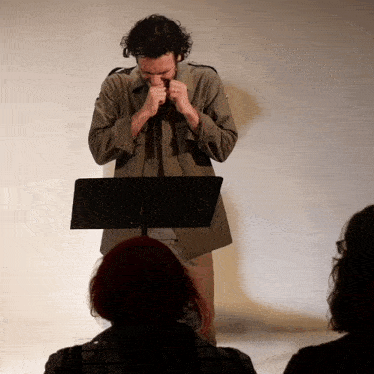 a man playing a harmonica while standing in front of a podium