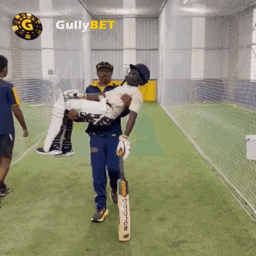a man is carrying a cricket player in his arms with gullybet written on the bottom