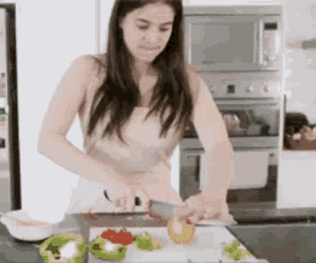 a woman is cutting vegetables on a cutting board .