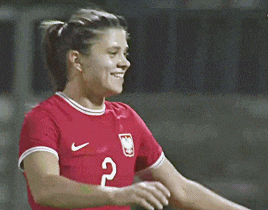 two female soccer players are hugging each other and one has the number 2 on her jersey