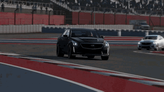 a black cadillac is driving on a track