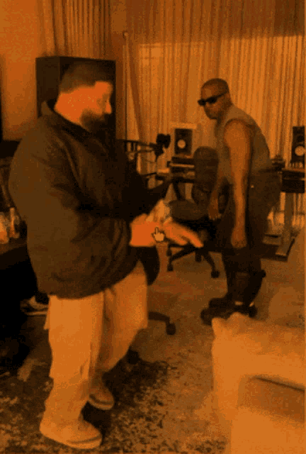 two men are standing in a room and one is holding a wallet