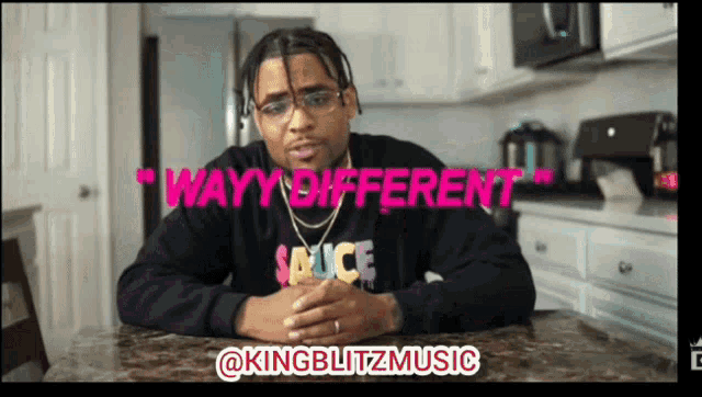 a man wearing a sauce sweatshirt is sitting at a table