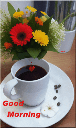a cup of coffee sits on a plate next to a vase of flowers