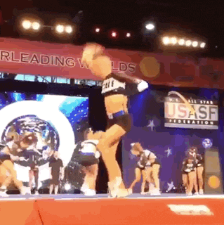 a cheerleader is jumping in the air while performing on a stage .