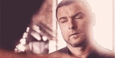 a close up of a man 's face with his eyes closed and a beard .