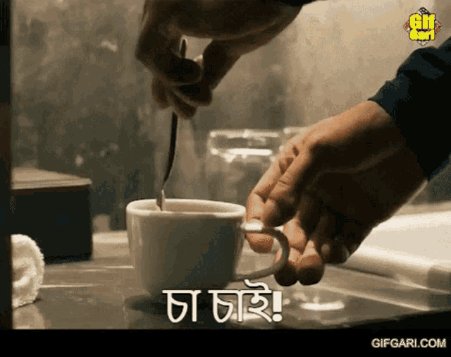 a person is stirring a cup of coffee with a spoon and the words " gifgari.com " are visible on the bottom