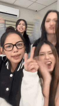 a group of young women are posing for a picture and one of them is wearing glasses