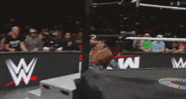 a wrestling match is going on in front of a sign that says ' raw '