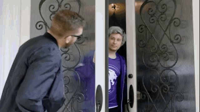 a man and a woman are standing in a doorway .