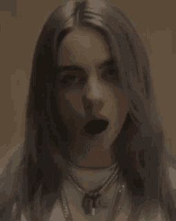 billie eilish has a spider on her face and a spider in her mouth .