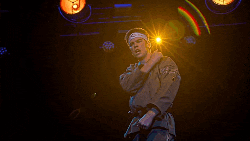a man in a karate uniform is standing in front of a bright light