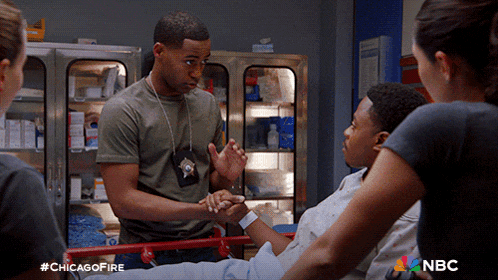 a group of people are gathered around a person on a stretcher with the hashtag #chicagofire on the bottom