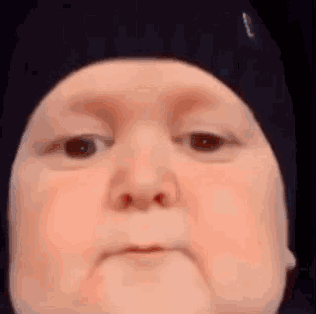 a close up of a baby 's face wearing a hat .