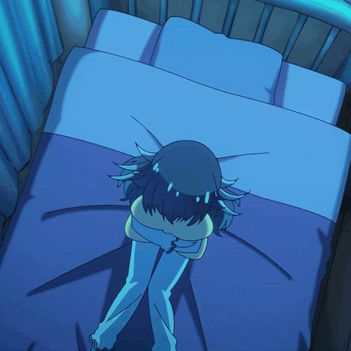 a girl laying on a bed holding a pillow with her eyes closed