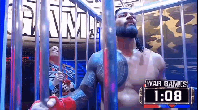 a man is standing in a cage with a sign that says war games at the bottom .
