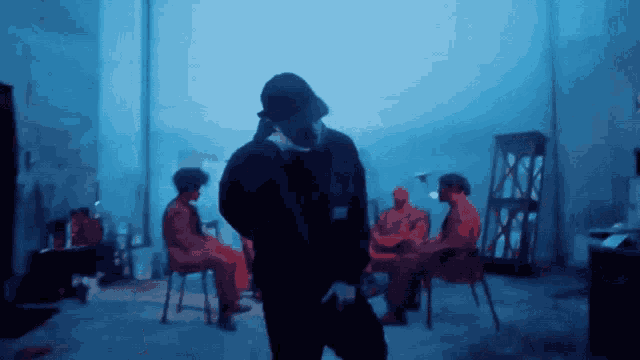 a man in a hat is standing in a room with other people