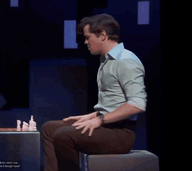 a man in a green shirt is playing chess