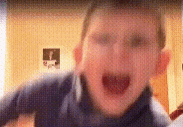 a young boy is making a funny face with his mouth open