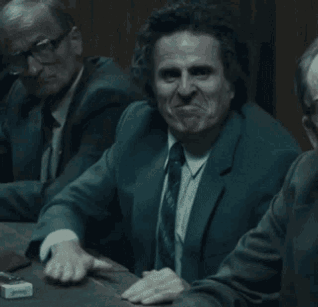 a man in a suit and tie is making a face