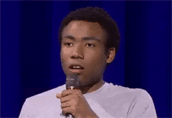 a man is holding a microphone and says `` good '' .