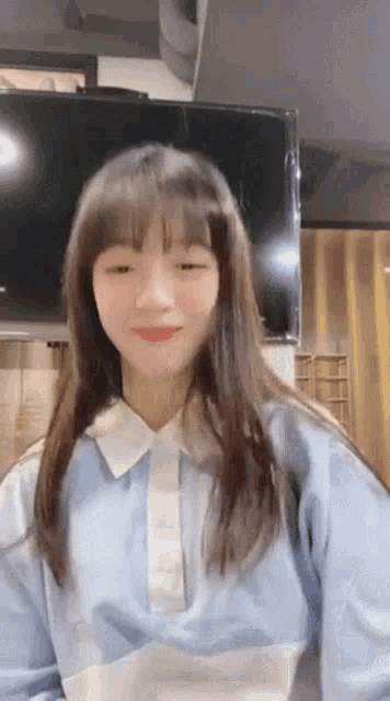 the girl is wearing a blue and white shirt and smiling for the camera