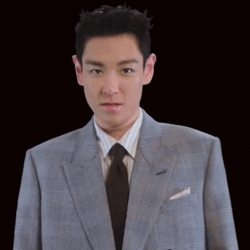 a man in a suit and tie points his finger