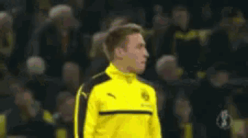 a soccer player in a yellow and black puma jacket