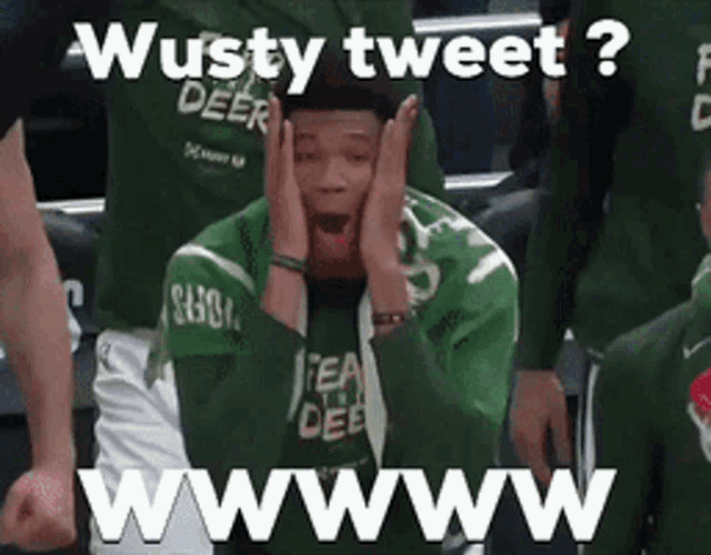 a man in a green shirt is sitting in a stadium with his hands on his face and the words wussy tweet ? wwwwww