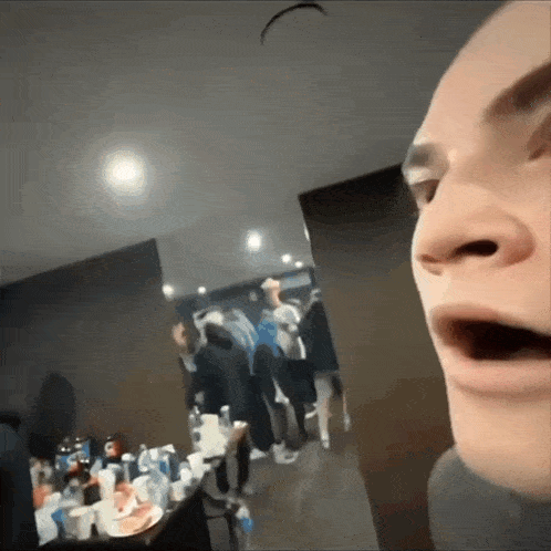 a man is making a funny face in front of a crowd of people